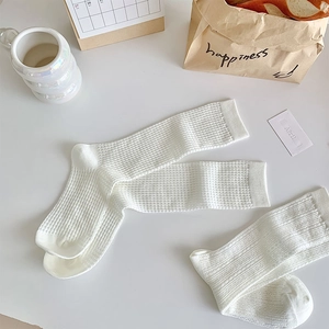 Close-up of white waffle texture lace socks with breathable cotton knit details