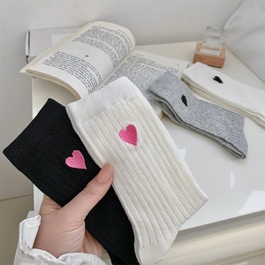 Detail of ribbed knit crew socks with embroidered heart pattern and vertical stripes