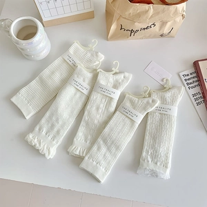 Detail of five-pack white lace Lolita socks with mesh knit patterns and branded packaging