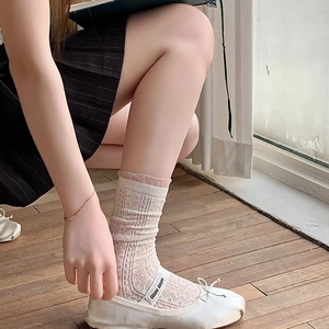 Detail of white crochet lace socks paired with leather ballet flats in balletcore style