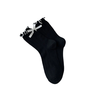 Black mesh crew socks with white ruffled trim and satin bow accents in ballet style
