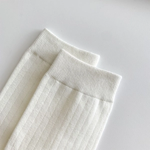 Detailed macro view of white ribbed knit fabric and elastic cuff on split toe socks