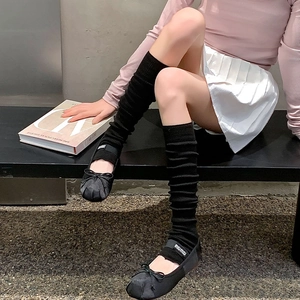 Detail of ballet flats with bow and elastic logo band paired with slouchy socks