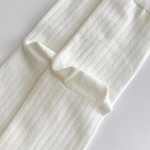 Detailed macro view of white ribbed knit fabric texture on breathable tabi socks