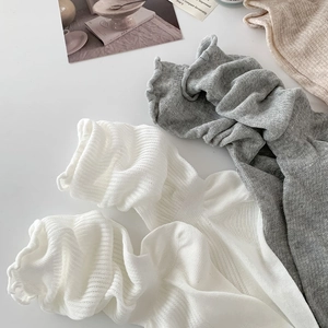 Close-up of ribbed knit cotton socks with delicate ruffle edges in neutral colors