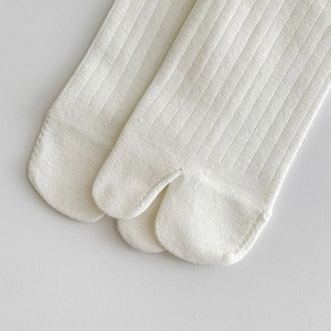 Close-up of cream white ribbed tabi socks showing the high-quality split toe stitching detail