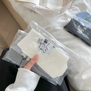 Détail de chaussettes en coton avec broderie chat dans un emballage zippé haut de gamme