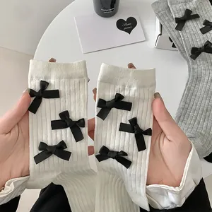 Detailed close-up of ribbed JK socks with black silk bows in white and gray colors