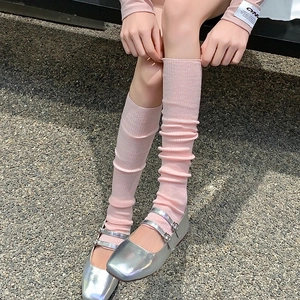 Detailed texture of pink ribbed slouch socks paired with silver Mary Jane shoes