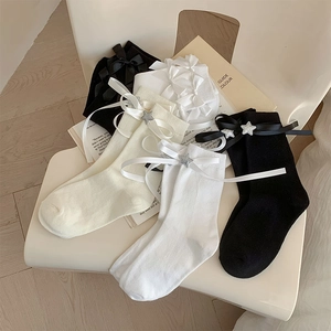 Détail de chaussettes Lolita avec nœuds en ruban et paillettes étoilées argentées