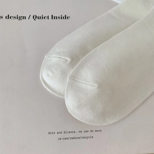 Detail showing the seamless toe stitching and fine knit texture of white cotton socks