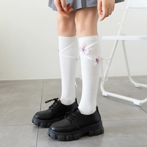 Detailed side view of Lolita knee-high socks featuring pink butterfly embroidery and ribbons