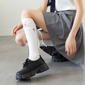 Japanese Lolita white knee high socks featuring pink butterfly embroidery and ribbon laces