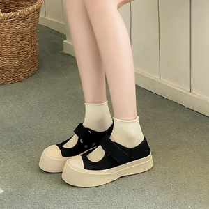 Close-up of retro platform Mary Jane canvas shoes with velcro strap on a wooden background