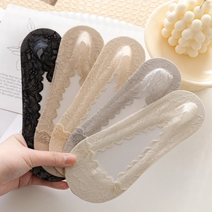 Gros plan de cinq couleurs de chaussettes invisibles en dentelle aux motifs floraux