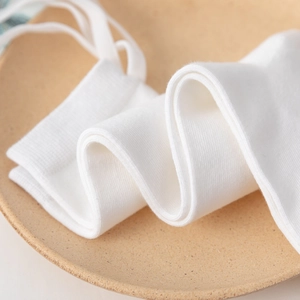Detailed macro view of white ribbed knit fabric texture on Lolita style knee high socks