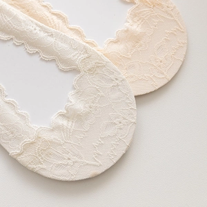 Détail de chaussettes invisibles en dentelle avec broderie florale et bords festonnés
