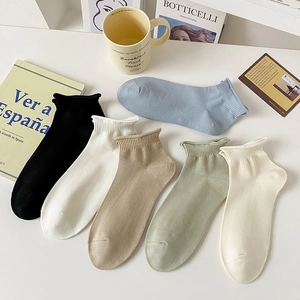 Detailed close-up of six-color ribbed cotton socks in various pastel shades on a white desk