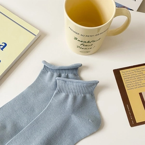 Close-up of light blue cotton socks with ribbed cuffs on a cozy desk setting