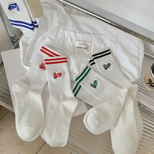 Detail of four-color striped cotton socks with Three embroidery in sporty college style