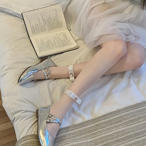 Detail of silver Mary Jane shoes with pink gem anklets on white sheer stockings