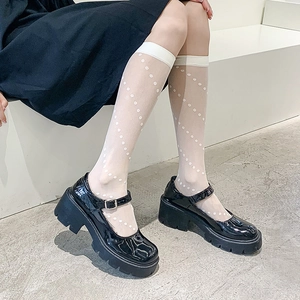 Detail of white semi-transparent polka dot high socks with black platform Mary Janes