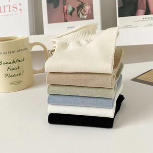 Close-up of pastel knitted cotton socks with ribbed texture and rolled cuffs in 6 colors