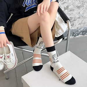 Artistic mid-calf cotton socks featuring abstract face illustration and orange stripes