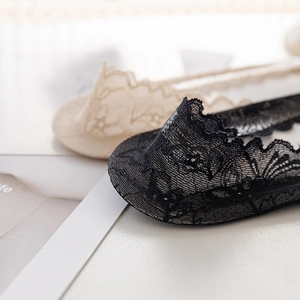 Détail du motif en dentelle florale sur des chaussettes invisibles noir et beige