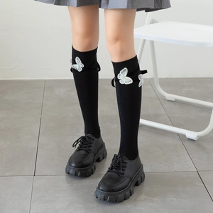 Detail of Lolita knee-high socks with butterfly embroidery and platform loafers