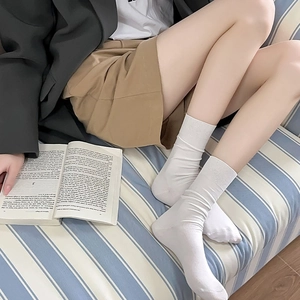Close-up of white ribbed knit crew socks with casual slouchy texture on model