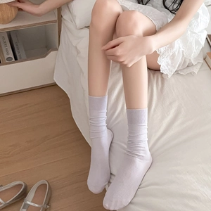 Detail of light purple ribbed crew socks in a cozy home setting with Mary Jane shoes
