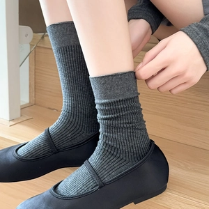 Detailed close-up of dark grey ribbed crew socks paired with black Mary Jane shoes