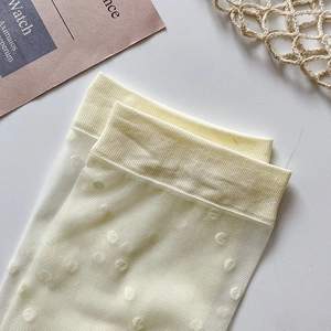 Detail of white ultra-thin JK style socks with micro polka dots and ribbed cuffs