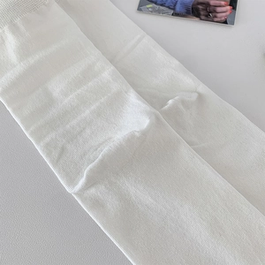 Detailed view of white ribbed knit fabric texture on premium cotton mid-calf socks