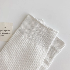 Detailed macro view of white ribbed cotton socks with soft vertical knit texture