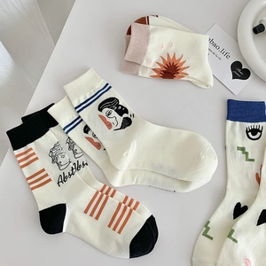 Detailed knit texture of mid-calf socks with abstract artistic patterns on white fabric