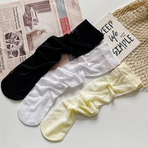 Detail of sheer polka dot knee-high socks in black, white, and yellow on vintage paper