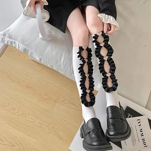 Detail of white Lolita socks featuring black ruffles and heart charms with loafers