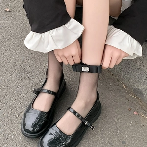 Detail of black transparent sheer socks with bow and rhinestone accent on Mary Jane shoes