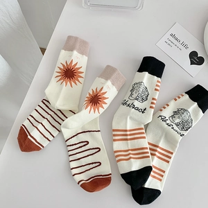Detail of artistic cotton socks featuring abstract sun patterns and portrait illustrations