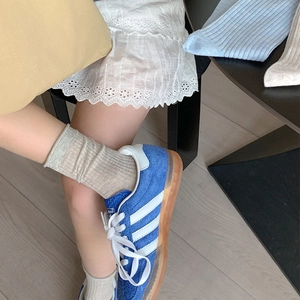 Gros plan de chaussettes en maille côtelée avoine avec bords roulés sur un modèle