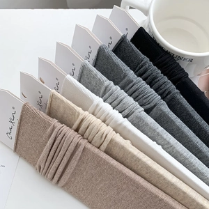 Detailed view of ribbed knit crew socks in various neutral tones with brand paper tags