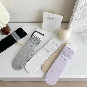 Detail of ribbed mid-calf socks in diverse colors with premium branded packaging tags
