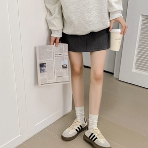 Detail of white dot mid-calf socks styled with a gray skirt and casual sneakers