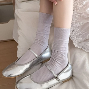 Pastel lavender ribbed crew socks paired with silver metallic Mary Jane flat shoes