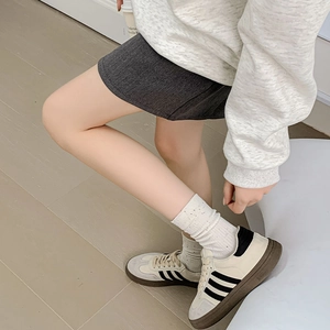Close-up of retro cream sports sneakers with black stripes and brown gum soles