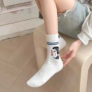 Detail of white cotton mid-calf socks with blue stripes and abstract art embroidery
