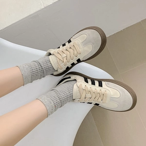 Detailed top view of retro beige suede sneakers with black stripes and grey knit socks