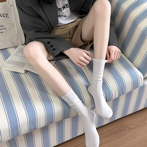 Close-up of white cotton mid-calf socks with ribbed cuffs on a casual home setting